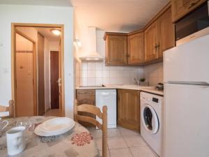 uma cozinha com uma mesa e um frigorífico branco em Appartement Saint-Lary-Soulan, 2 pièces, 6 personnes - FR-1-296-175 em Saint-Lary-Soulan