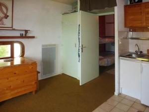 uma cozinha com uma porta e um lavatório num quarto em Studio Les Orres, 1 pièce, 4 personnes - FR-1-322-230 em Les Orres