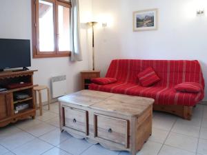 a living room with a red couch and a tv at Appartement Les Orres, 3 pièces, 8 personnes - FR-1-322-268 in Les Orres