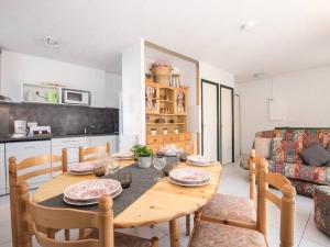eine Küche und ein Esszimmer mit einem Holztisch und Stühlen in der Unterkunft "Appartement lumineux 6 pers avec terrasse, parking, proche thermes et télécabine - Saint Lary Soulan" - FR-1-296-211 in Saint-Lary-Soulan