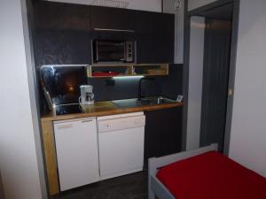 eine kleine Küche mit einer Spüle und einer Mikrowelle in der Unterkunft Studio Isola 2000, 1 pièce, 4 personnes - FR-1-292-75 in Isola 2000