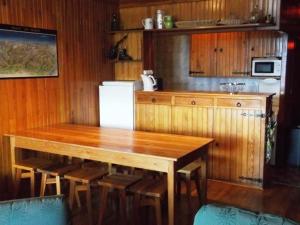 Una cocina con una mesa de madera y algunas sillas. en Appartement 3 pièces, 8 pers - Proche commerces et pistes à Orcières Merlette - FR-1-262-147, en Les Estaris