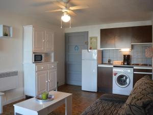 uma cozinha com um frigorífico branco e uma mesa em Appartement Saint-Cyprien, 2 pièces, 4 personnes - FR-1-225D-440 em Saint-Cyprien-Plage
