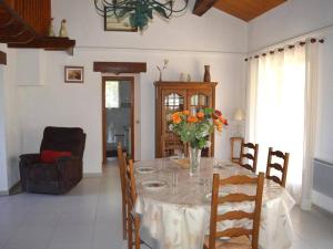 una mesa de comedor con un jarrón de flores. en Maison Argelès-sur-Mer, 5 pièces, 7 personnes - FR-1-225-460, en Argelès-sur-Mer