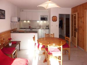 a kitchen and dining room with a wooden table and chairs at Appartement Les Orres, 2 pièces, 5 personnes - FR-1-322-280 in Les Orres