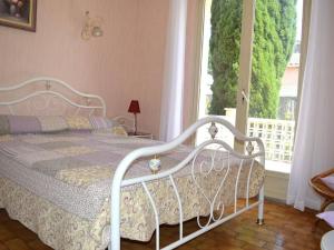 um quarto com uma cama branca e uma janela em Maison Argelès-sur-Mer, 5 pièces, 7 personnes - FR-1-225-460 em Argelès-sur-Mer