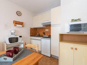 a small kitchen with a table and a microwave at Appartement Saint-Lary-Soulan, 2 pièces, 4 personnes - FR-1-296-134 in Saint-Lary-Soulan