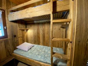 ein Etagenbett aus Holz in einer Holzhütte in der Unterkunft Appartement Le Grand-Bornand, 1 pièce, 5 personnes - FR-1-241-165 in Le Grand-Bornand