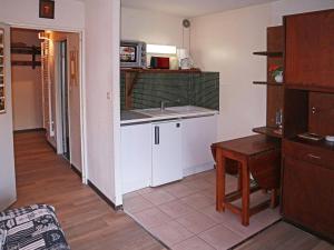 una cucina con lavandino, tavolo e forno a microonde di Appartement Les Orres, 1 pièce, 4 personnes - FR-1-322-282 a Les Orres