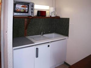 una cucina con lavello e forno a microonde su una mensola di Appartement Les Orres, 1 pièce, 4 personnes - FR-1-322-282 a Les Orres