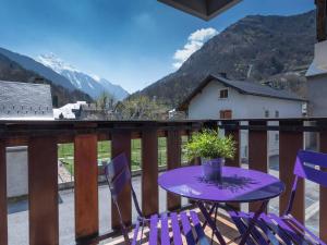 a purple table and chairs on a balcony with mountains at Appartement Saint-Lary-Soulan, 2 pièces, 6 personnes - FR-1-296-127 in Saint-Lary-Soulan