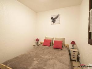 サン・ラリー・スランにあるAppartement Saint-Lary-Soulan, 2 pièces, 6 personnes - FR-1-296-156のベッドルーム1室(大型ベッド1台、赤い枕2つ付)