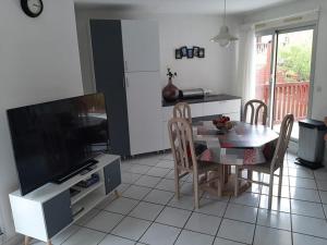 een keuken met een tafel en een televisie en een eetkamer bij Appartement T2 cabine avec terrasse et piscine à Vieux-Boucau, idéal pour les vacances ! - FR-1-379-18 in Vieux-Boucau-les-Bains