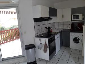 een keuken met een fornuis bovenste oven naast een raam bij Appartement T2 cabine avec terrasse et piscine à Vieux-Boucau, idéal pour les vacances ! - FR-1-379-18 in Vieux-Boucau-les-Bains