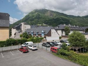 a parking lot with cars parked in front of a mountain at Appartement Saint-Lary-Soulan, 2 pièces, 6 personnes - FR-1-296-158 in Saint-Lary-Soulan