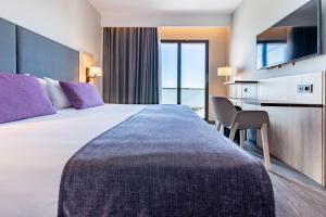 Habitación de hotel con cama grande y escritorio. en Astari, en Tarragona