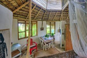 ein Zimmer mit einem Tisch und Stühlen in einem Haus in der Unterkunft Tropical Cottage En Eco Casa Algana in El Limón