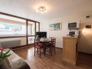 a living room with a table with chairs and a television at Appartement 4 personnes proche téléphérique, Saint Lary Village - FR-1-296-174 in Saint-Lary-Soulan