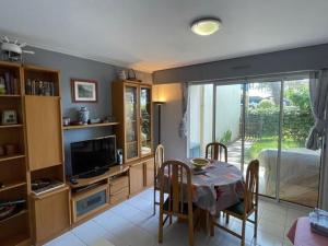 Un comedor con una mesa y un dormitorio. en Charmant T2 avec piscine et terrasse face au lac, parking privé, animaux acceptés - FR-1-379-55, en Soustons