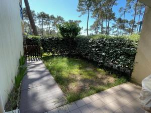 una pasarela que conduce a un patio con una valla en Charmant T2 avec piscine et terrasse face au lac, parking privé, animaux acceptés - FR-1-379-55, en Soustons