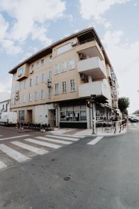 un grand bâtiment au coin d'une rue dans l'établissement Hotel Delphos, à Moraleja