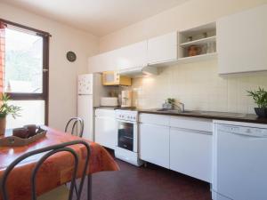 a kitchen with white appliances and a table with a tableablish at Appartement 6 pers, 3 chambres, proche centre et pistes, parking privé, balcon, tout confort - FR-1-296-176 in Saint-Lary-Soulan