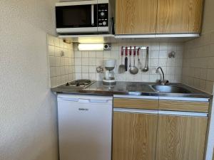 una piccola cucina con lavandino e forno a microonde di Appartement Puy-Saint-Vincent, 1 pièce, 4 personnes - FR-1-330G-44 a Puy-Saint-Vincent