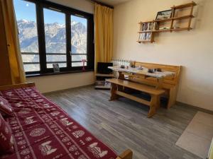 a room with a bed and a table and a window at Appartement Puy-Saint-Vincent, 1 pièce, 4 personnes - FR-1-330G-44 in Puy-Saint-Vincent