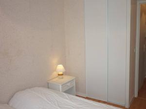 ein Schlafzimmer mit einem Bett und einer Lampe auf einem Nachttisch in der Unterkunft Appartement Cabourg, 2 pièces, 4 personnes - FR-1-465-21 in Cabourg