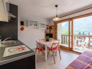 eine Küche mit einem Tisch mit Stühlen und einem Balkon in der Unterkunft Agréable studio cabine 4 pers avec parking à Saint-Lary village - FR-1-296-218 in Saint-Lary-Soulan
