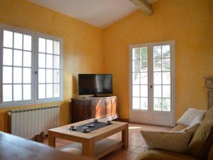 ein Wohnzimmer mit einem Sofa und einem TV in der Unterkunft Maison Banyuls-sur-Mer, 5 pièces, 8 personnes - FR-1-225C-470 in Banyuls-sur-Mer