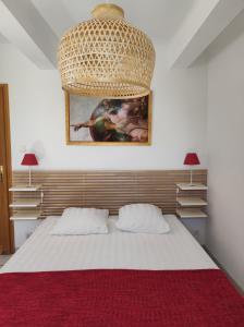 a bedroom with a large bed with a red blanket at Le Mas des Aludes in La Destrousse