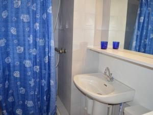 a bathroom with a sink and a blue shower curtain at Appartement Banyuls-sur-Mer, 1 pièce, 4 personnes - FR-1-225C-461 in Banyuls-sur-Mer