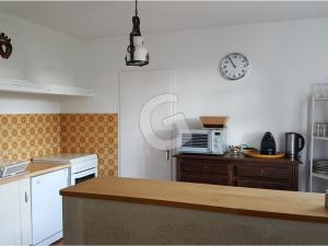 a kitchen with a counter and a clock on the wall at Maison Saint-Vincent-sur-Jard, 4 pièces, 6 personnes - FR-1-357-32 in Saint-Vincent-sur-Jard