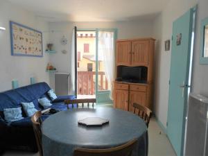 ein Wohnzimmer mit einem Tisch und einem blauen Sofa in der Unterkunft Appartement T2 Cabine à Vieux-Boucau avec Balcon, Animaux Admis - FR-1-379-24 in Vieux-Boucau-les-Bains