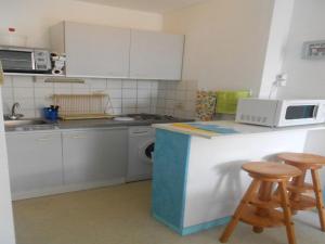 eine Küche mit einer Theke und 2 Hockern in der Unterkunft Appartement T2 Cabine à Vieux-Boucau avec Balcon, Animaux Admis - FR-1-379-24 in Vieux-Boucau-les-Bains + 4 Fotos