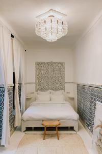 um quarto com uma cama e um lustre em Riad Maison 24 em Marrakech