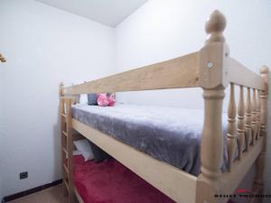 a wooden bunk bed in a bedroom with a pink flower at Appartement 4 personnes à Saint Lary village - FR-1-296-231 in Saint-Lary-Soulan