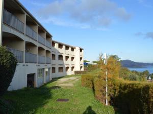 un gran edificio blanco con un patio junto a un lago en Appartement Banyuls-sur-Mer, 2 pièces, 4 personnes - FR-1-225C-488, en Banyuls-sur-Mer