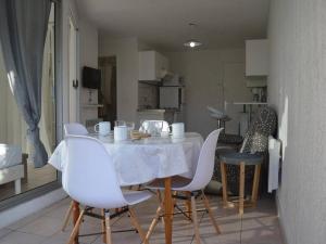 聖普里安海灘的住宿－Appartement Saint-Cyprien, 2 pièces, 4 personnes - FR-1-225D-472，一间带桌子和白色椅子的用餐室