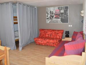 sala de estar con sofá rojo y autobús de 2 pisos rojo en Studio Montgenèvre, 1 pièce, 5 personnes - FR-1-266-85, en Montgenèvre