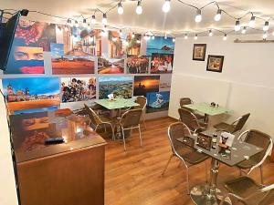 een restaurant met tafels en stoelen en foto's aan de muur bij Hotel Santa Cruz Bogotá in Bogota