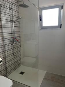 bagno con doccia e porta in vetro di Los Gracioseras 2 Bed Apt no 218 - AC, WIFI, UK TV a Tías