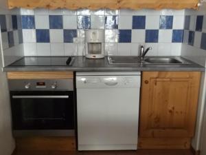 a kitchen with a sink and a stove at Appartement Orcières Merlette, 3 pièces, 6 personnes - FR-1-262-154 in Les Estaris