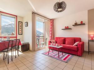 Una sala de estar con un sofá rojo y una mesa. en Appart 2 pièces avec balcon, près des pistes - Briançon - FR-1-330C-20, en Briançon