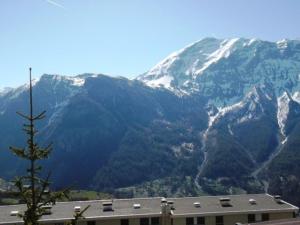 a view of a snow covered mountain with a building at Maxi-studio 6 pers avec balcon sud, proche commerces et sports, accès pistes navette gratuite - FR-1-262-155 in Forest des Baniols +4 photos