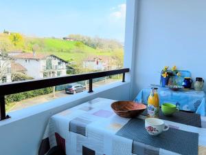 a table on a balcony with a view of a street at Studio Cambo-les-Bains, 1 pièce, 4 personnes - FR-1-495-64 in Cambo-les-Bains