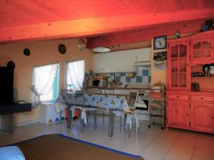 una cocina con armarios rojos y una mesa con sillas. en Appartement Vieux-Boucau-les-Bains, 3 pièces, 6 personnes - FR-1-379-28, en Vieux-Boucau-les-Bains