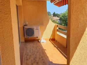 a balcony with a fan on the side of a building at Appartement Argelès-sur-Mer, 3 pièces, 4 personnes - FR-1-388-128 in Argelès-sur-Mer