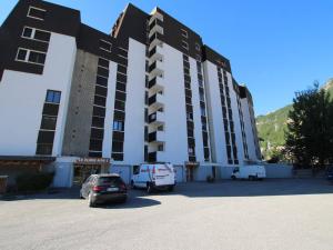 セレ・シュヴァリエにあるAppartement Serre Chevalier, 1 pièce, 4 personnes - FR-1-330F-66の駐車場車を停めた大きな建物